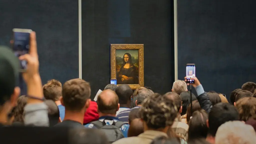 Tourists capturing the iconic Mona Lisa painting at the Louvre Museum.